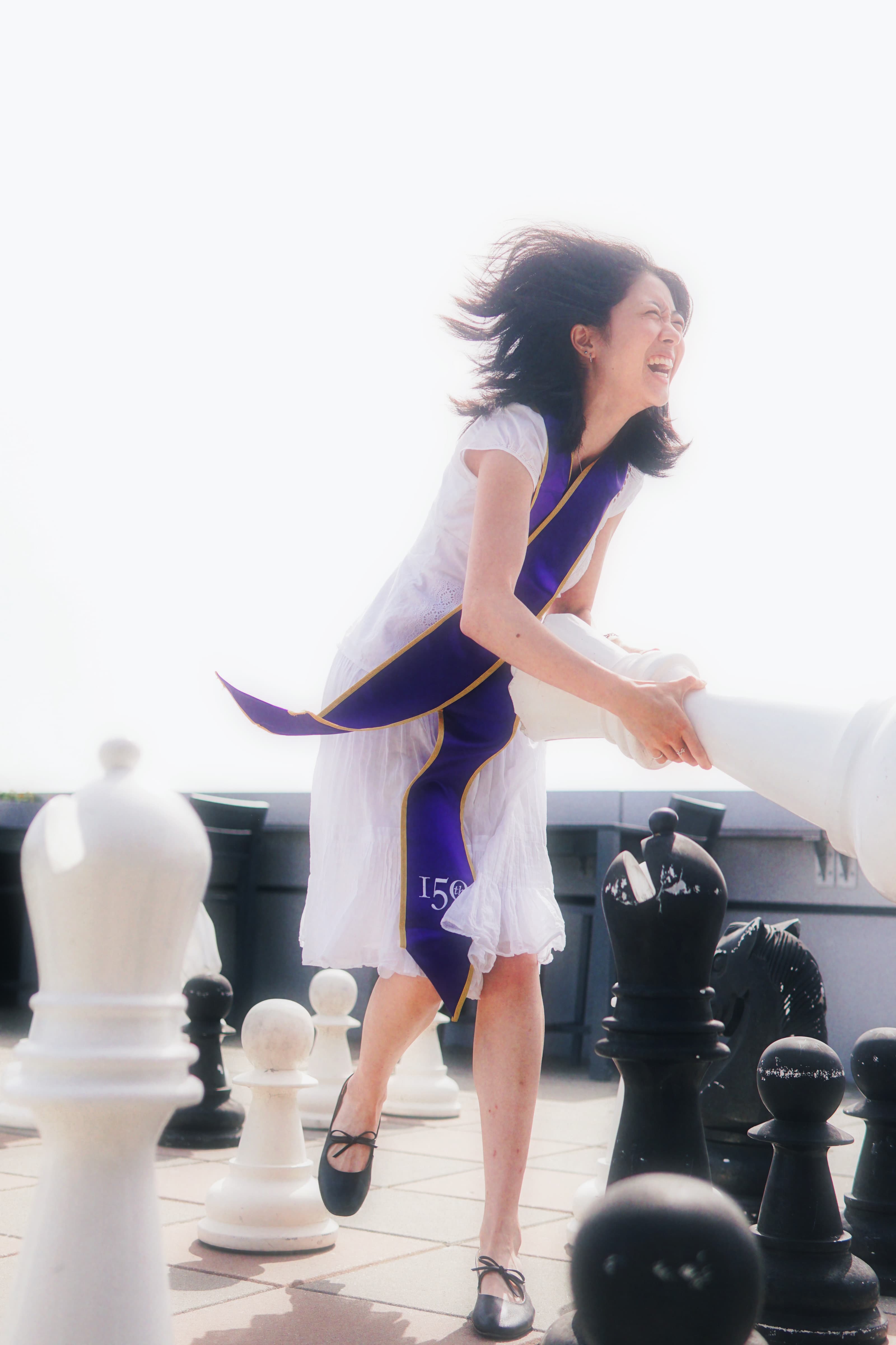 girl swinging large chess piece