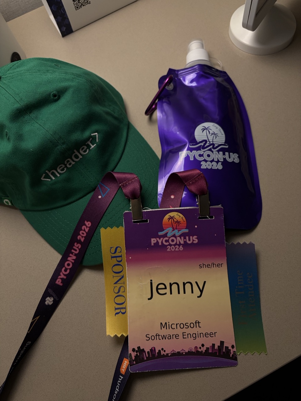 My PyCon US 2026 badge, first-time attendee ribbon, and swag